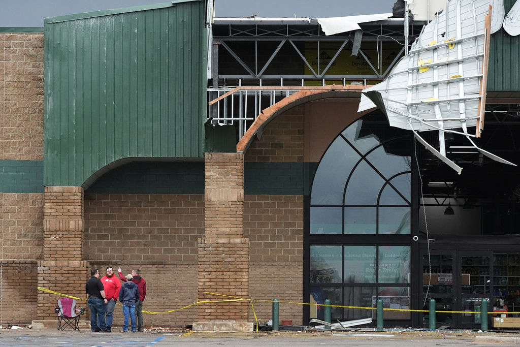 People stand outside a storm-damaged Menards store in the aftermath of a powerful storm that ripped through the area a day earlier, in Three Rivers, Mich., Saturday, March 7, 2026. (AP Photo/Nam Y. Huh)