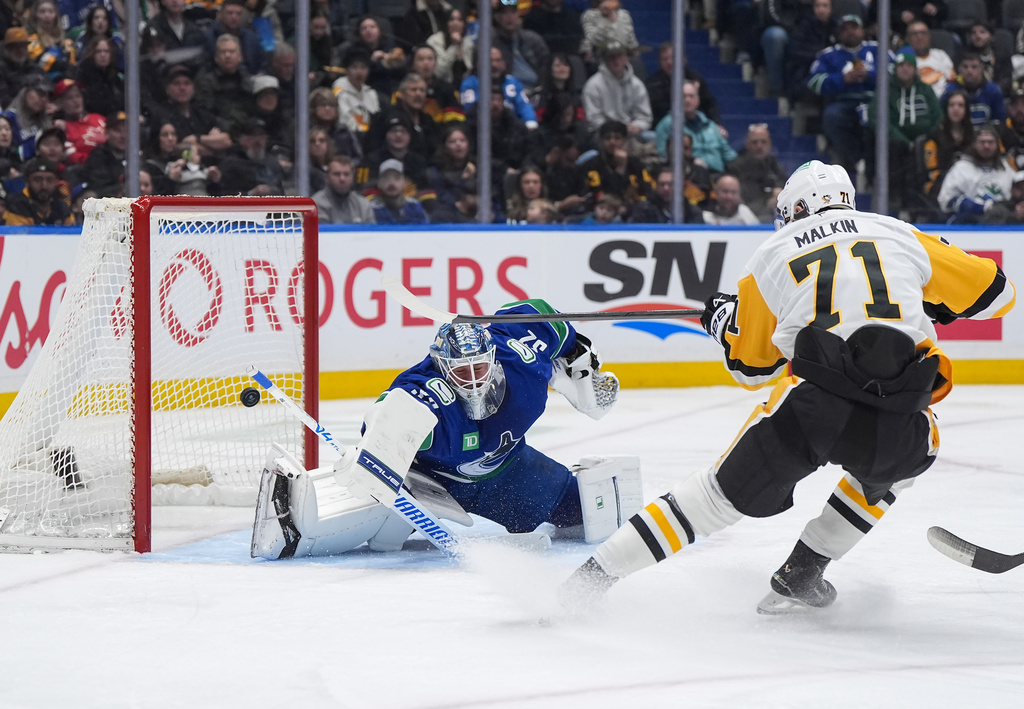 Pittsburgh Penguins' Evgeni Malkin (71) scores against Vancouver Canucks goalie Kevin Lankinen, left, during second-period NHL hockey game action in Vancouver, British Columbia, Sunday, Jan. 25, 2026. (Darryl Dyck/The Canadian Press via AP)