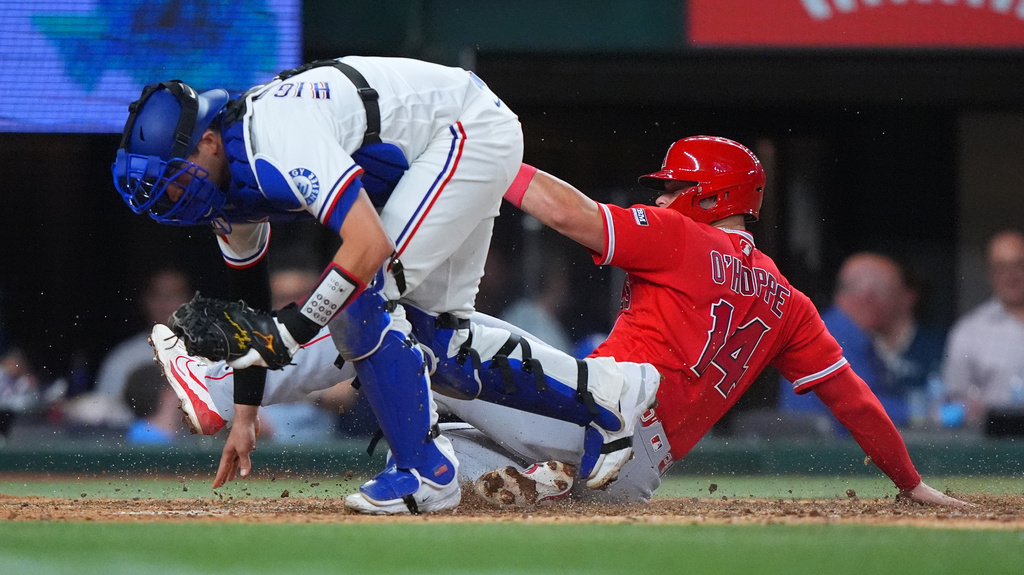 Los Angeles Angels' Logan O'Hoppe (14) is out at home plate against Texas Rangers catcher Kyle Higashioka (11) on a bases loaded force out during the seventh inning of a baseball game, Thursday, July 9, 2026, in Arlington, Texas. (AP Photo/LM Otero)
