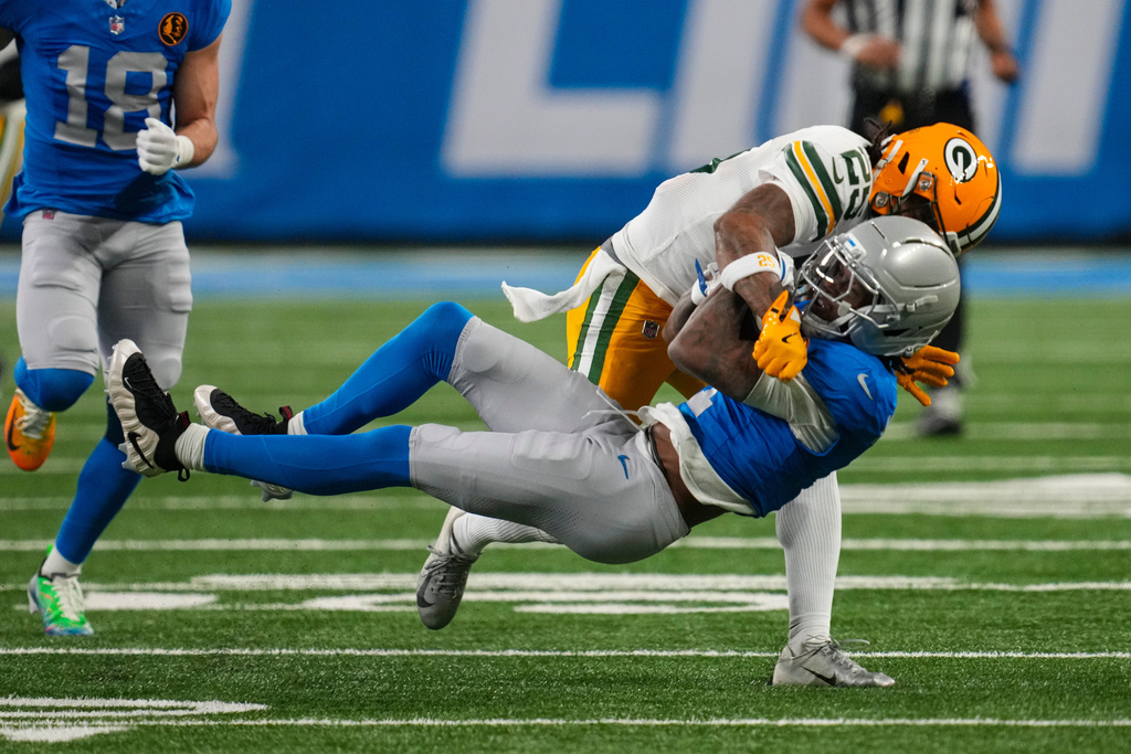 Detroit Lions wide receiver Jameson Williams (1) is tacked by Green Bay Packers cornerback Keisean Nixon (25) during the first half an NFL football game in Detroit, Thursday, Nov. 27, 2025. (AP Photo/Paul Sancya)