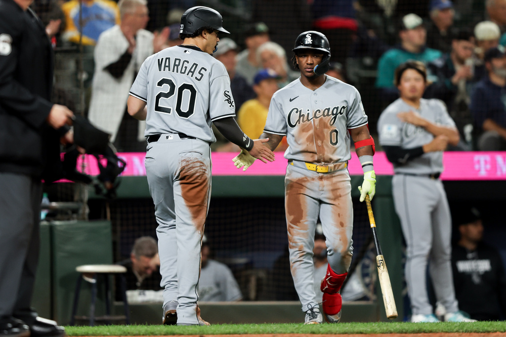 Chicago White Sox' Miguel Vargas (20) celebrates after scoring with Luisangel Acuña (0) in the ninth inning of a baseball game against the Seattle Mariners, Tuesday, May 19, 2026, in Seattle. (AP Photo/Kevin Ng)