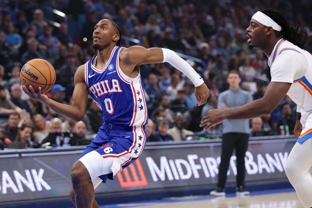 Philadelphia 76ers guard Tyrese Maxey (0) goes to the basket past Oklahoma City Thunder guard Luguentz Dort, right, during the first half of an NBA basketball game, Sunday, Dec. 28, 2025, in Oklahoma City. (AP Photo/Nate Billings)