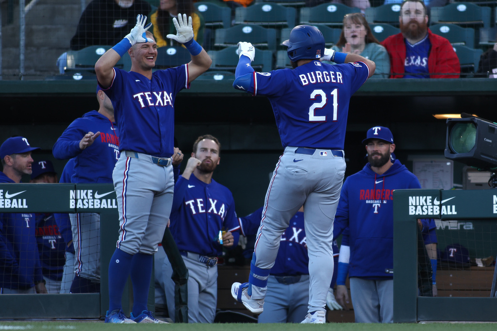 Texas Rangers' Jake Burger (21) is congratulated by Josh Jung, front left, after hitting a three-run home run during the first inning of a baseball game against the Athletics, Monday, April 13, 2026, in West Sacramento, Calif. (AP Photo/Scott Marshall)