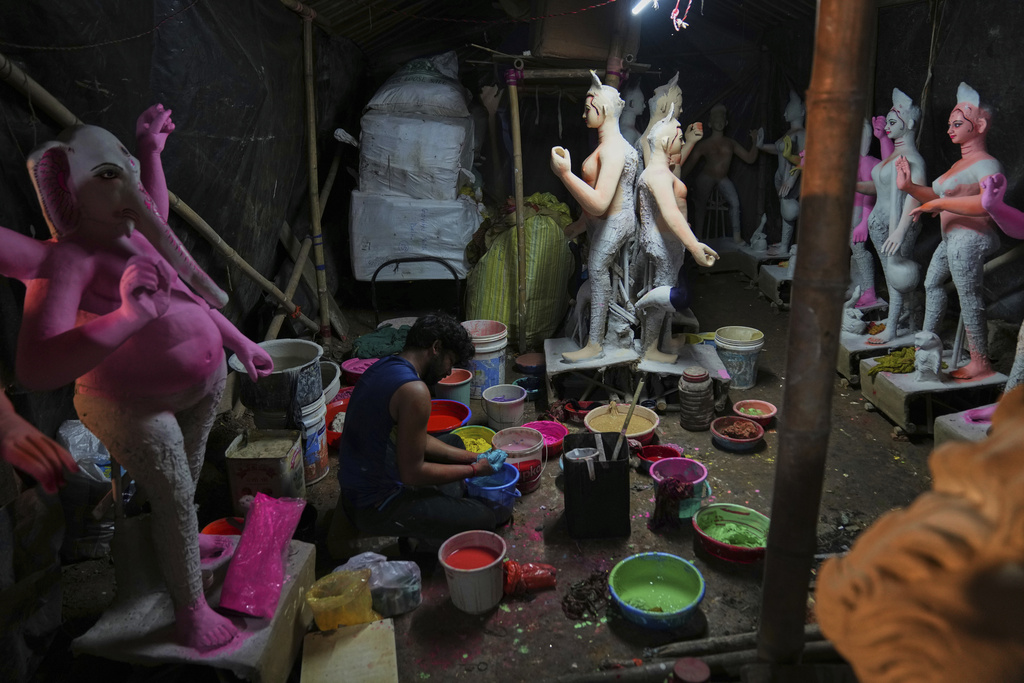 An artist from Kolkata prepares different colors for painting idols of Hindu deities ahead of the Durga Puja festival at a temporary shelter in New Delhi, India, Friday, Sept. 19, 2025. (AP Photo/Manish Swarup)