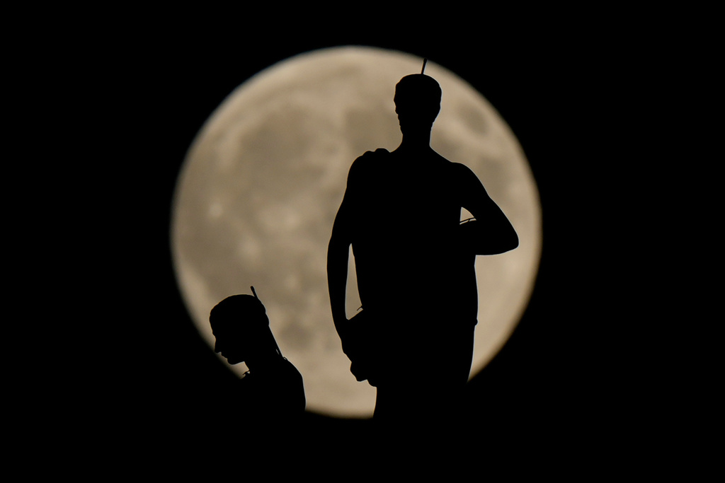 The Harvest Supermoon rises behind spires of the Duomo gothic cathedral, in Milan, Monday, Oct. 6, 2025. (AP Photo/Luca Bruno)