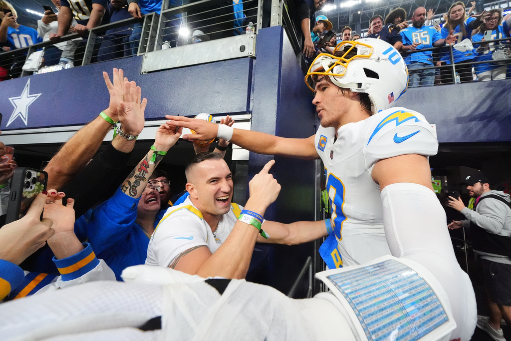 Los Angeles Chargers quarterback Justin Herbert (10) celebrates with fans after a win over the Dallas Cowboys in an NFL football game Sunday, Dec. 21, 2025, in Arlington, Texas. (AP Photo/Julio Cortez)