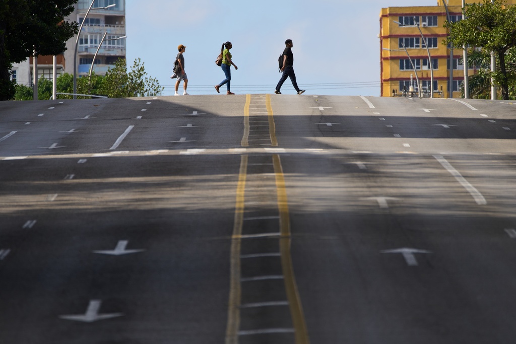 pedestrians cross a street in Havana, Cuba, Saturday, Feb. 14, 2026. (AP Photo/Ramon Espinosa)