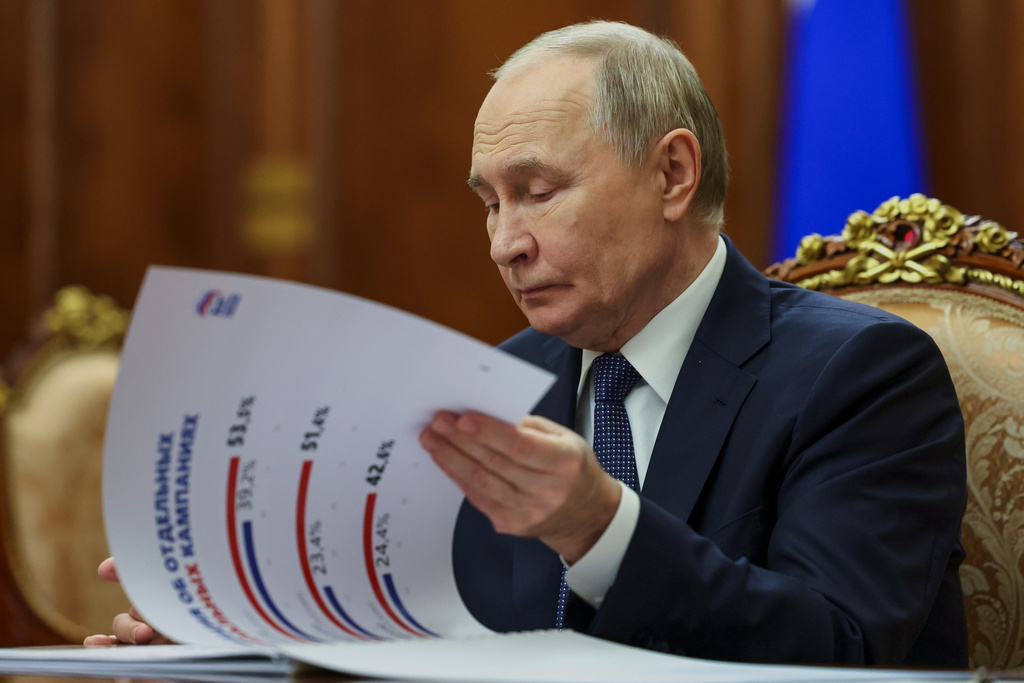 Russian President Vladimir Putin looks at papers while listening to Secretary of United Russia party's General Council Vladimir Yakushev during their meeting at the Kremlin, in Moscow, on Monday, Dec. 15, 2025. (Mikhail Metzel, Sputnik, Kremlin Pool Photo via AP)