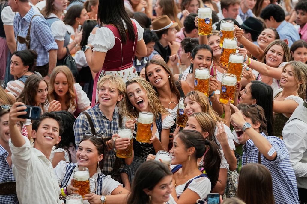 Young people cheer after the opening of the 191st Oktoberfest beer festival in Munich, Germany, Saturday, Sept.19, 2026. (AP Photo/Matthias Schrader)