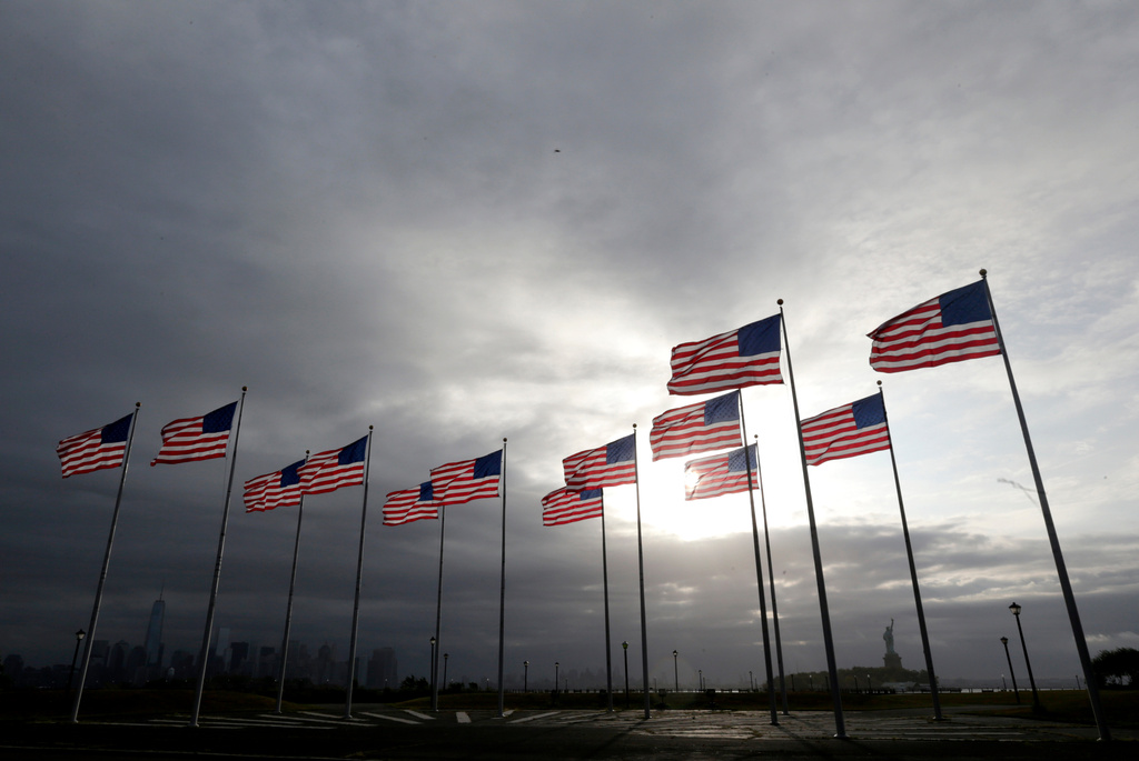 FILE - Thirteen United States flags representing the 13 original colonies are seen at Liberty State Park with 1 World Trade Center, bottom left, and the Statue of Liberty, bottom right, in the background, Sept. 11, 2014, in Jersey City, N.J. (AP Photo/Julio Cortez, File)