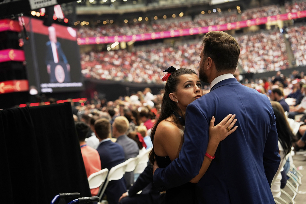 Attendees listen as President Donald Trump, on screen at left, speaks at a memorial for conservative activist Charlie Kirk, Sunday, Sept. 21, 2025, at State Farm Stadium in Glendale, Ariz. (AP Photo/Julia Demaree Nikhinson)