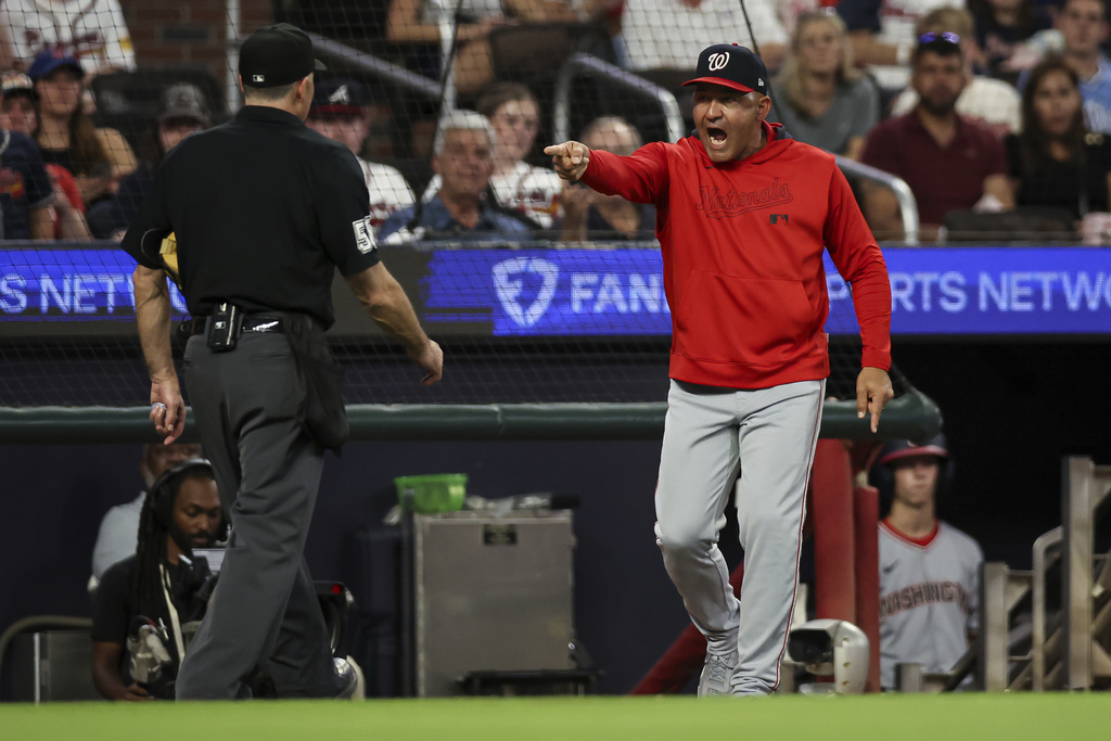 Washington Nationals interim manager Miguel Cairo, right, argues with home plate umpire Dan Iassogna, left, after being ejected by first base umpire Manuel González during the third inning of a baseball game against the Atlanta Braves, Monday, Sept. 22, 2025, in Atlanta. (AP Photo/Colin Hubbard)