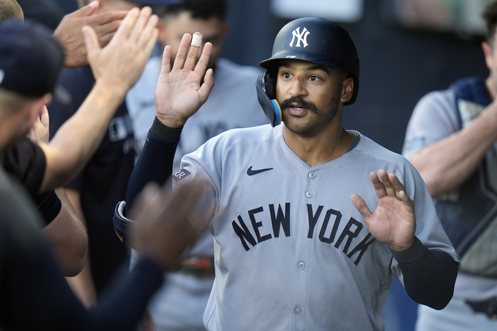 New York Yankees' Trent Grisham celebrates with teammates in the dugout after his solo home run. off Tampa Bay Rays pitcher Drew Rasmussen during the first inning of a baseball game Wednesday, Aug. 20, 2025, in Tampa, Fla. (AP Photo/Chris O'Meara)
