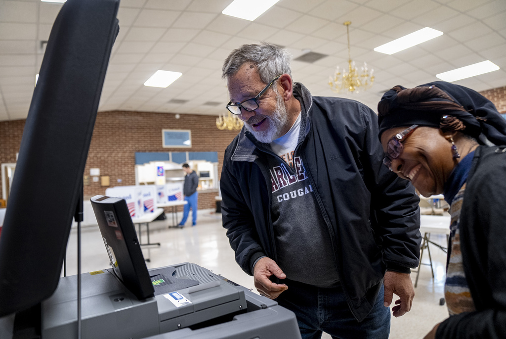 FILE - A man shares a laugh with a poll worker as he casts his vote on the morning of the South Carolina Republican primary at Cayce United Methodist Church in Cayce, S.C., Saturday, Feb. 24, 2024. (AP Photo/Andrew Harnik, file)