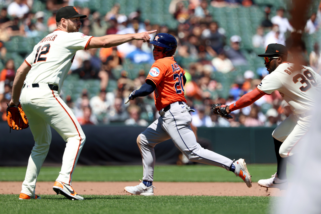 Houston Astros' Nick Allen (20) is tagged out in a rundown by San Francisco Giants shortstop Osleivis Basabe (39) in front of Adrian Houser (12) during the sixth inning of a baseball game in San Francisco, Wednesday, Aug. 12, 2026. (AP Photo/Jed Jacobsohn)