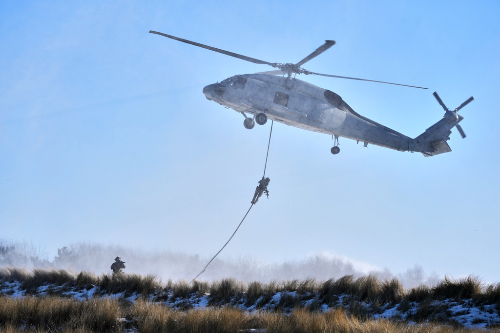 Soldiers rappel from a helicopter as they arrive on the beach during an amphibious landing operation conducted by the Allied Reaction Force during NATO led military exercises on Wessek Beach in Putlos, Germany, Wednesday, Feb. 18, 2026. (AP Photo/Virginia Mayo)