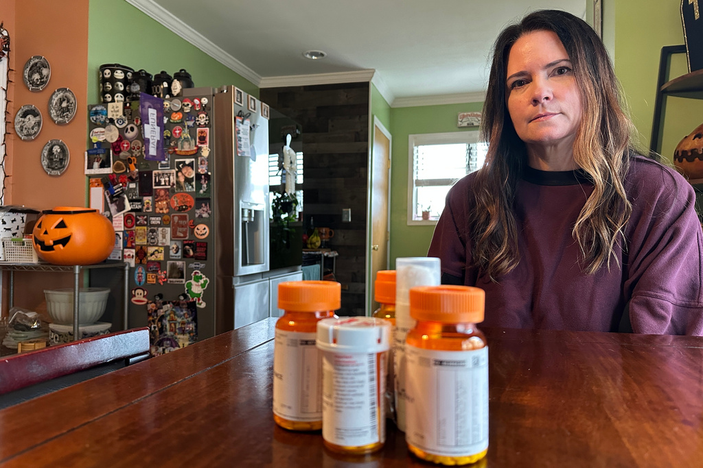 Local hair stylist Christine Meehan sits in front of her medication while talking about the possible increase in her health insurance fee at her home in Upper Chichester, Pa., Monday, Oct. 13, 2025. (AP Photo/Tassanee Vejpongsa)