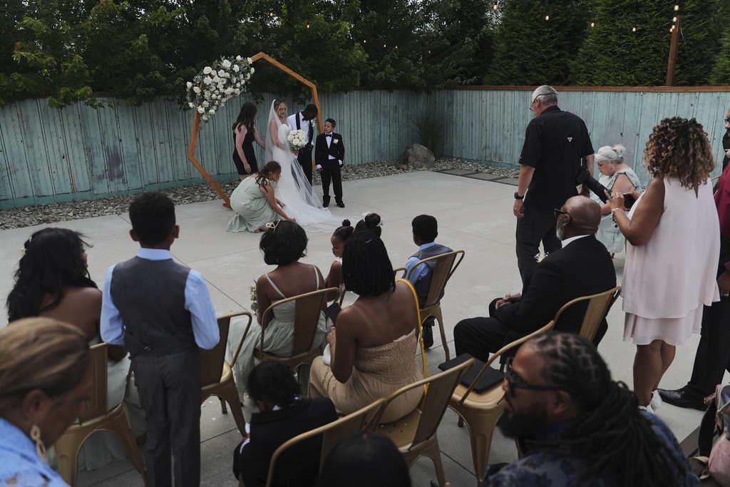 Newlyweds Kayla McDonald and Tyler Jones pose for family photos during their wedding Saturday, Aug. 23, 2025, in Newtown, Ohio. (AP Photo/Joshua A. Bickel)
