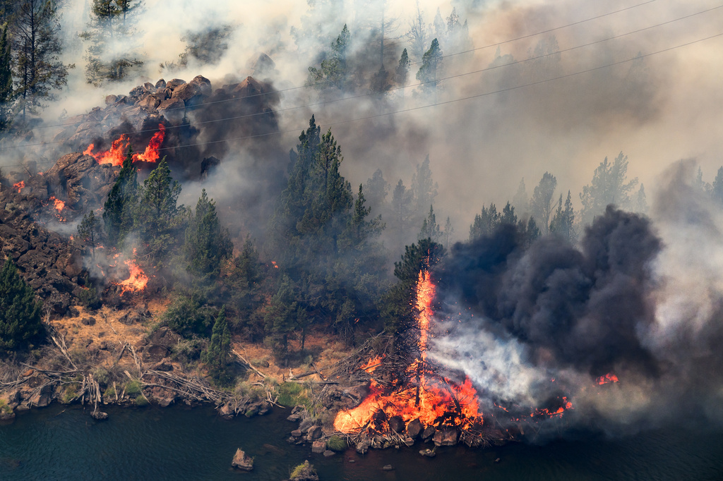 The Bench fire burns along the banks of the Deschutes River on Saturday, July 25, 2026, in Jefferson County, Ore. (AP Photo/Noah Berger)