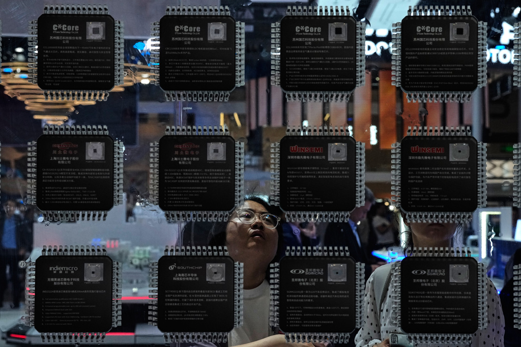 A woman looks at various of Chinese made chips for the automotive market showcased at the Auto China 2026, in Beijing, Saturday, April 25, 2026. (AP Photo/Andy Wong)