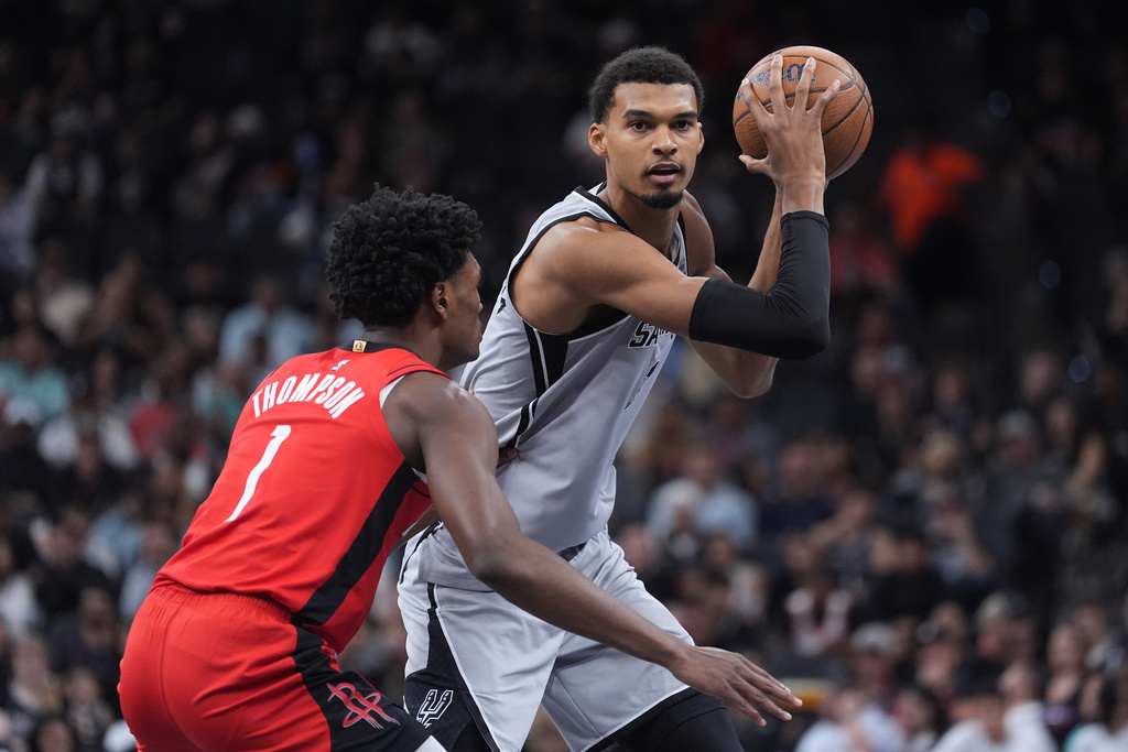 San Antonio Spurs forward Victor Wembanyama, right, is defended by Houston Rockets guard Amen Thompson, left, during the first half of an NBA Cup basketball game in San Antonio, Friday, Nov. 7, 2025. (AP Photo/Eric Gay)