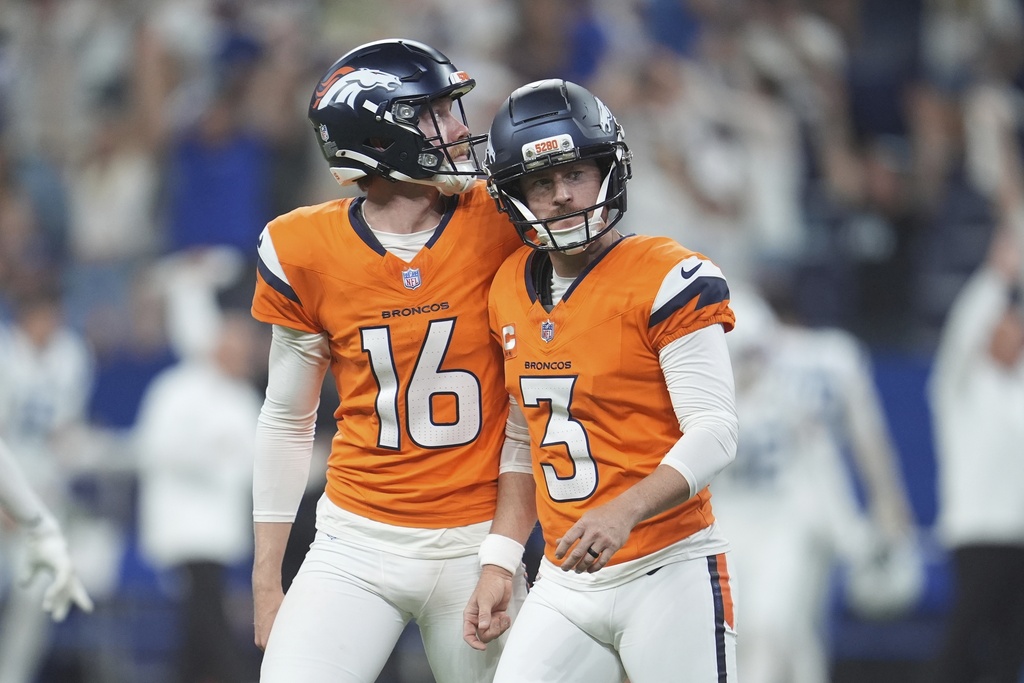 Denver Broncos place kicker Wil Lutz (3) walks off the field with Jeremy Crawshaw and Lutz missed a field goal during the second half an NFL football game against the Indianapolis Colts, Sunday, Sept. 14, 2025, in Indianapolis. (AP Photo/Michael Conroy)