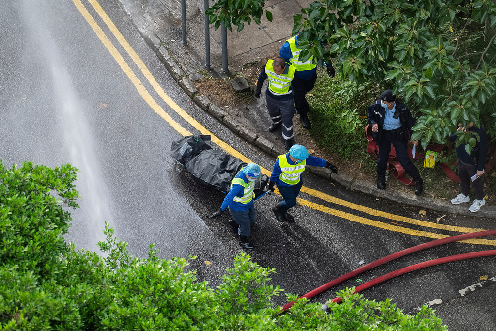 Workers remove a body from a fire which broke out Wednesday at Wang Fuk Court, a residential estate in the Tai Po district of Hong Kong's New Territories, Thursday, Nov. 27, 2025. (AP Photo/Chan Long Hei)