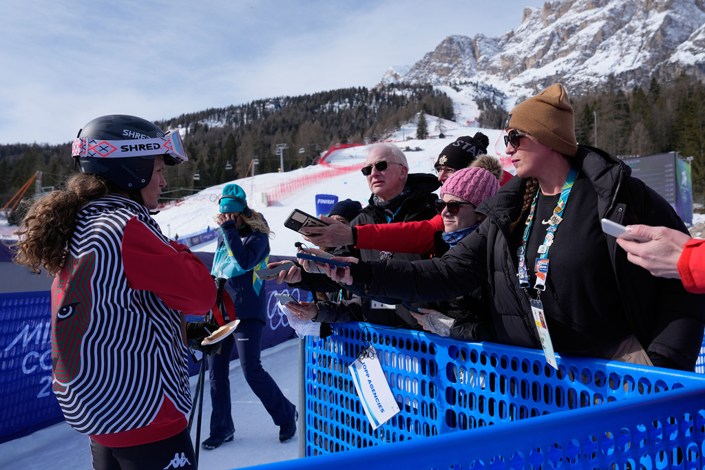 ESPN reporters Sarah Spain, right, and Alex Azzi interview alpine skier Sarah Schleper, of Mexico, are seen at the 2026 Winter Olympics in Cortina d'Ampezzo, Italy, Sunday, Feb. 15, 2026. (AP Photo/Andy Wong)