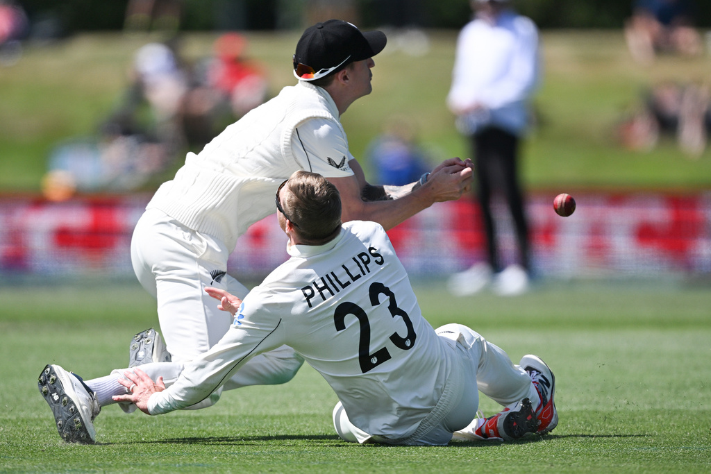 New Zealand fielders Blair Tickner, left, and Glenn Phillips are unable to field a ball while playing the West Indies on Day 5 of their cricket test match in Christchurch, New Zealand, Saturday, Dec. 6, 2025. (Andrew Cornaga/Photosport via AP)
