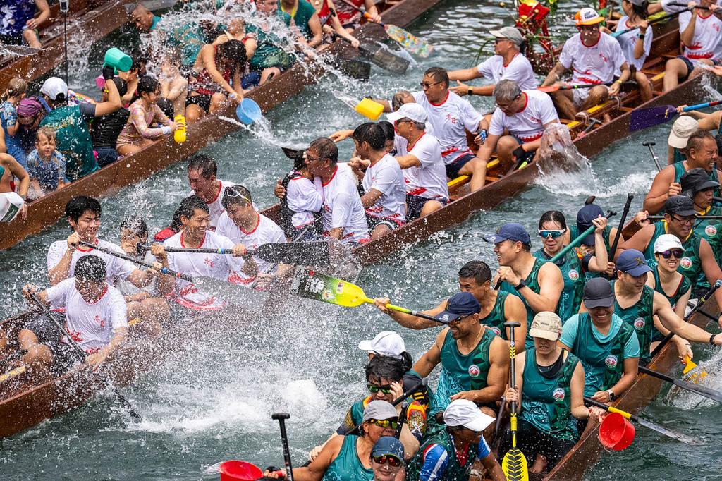 Competitors splash water on each other during the Aberdeen Dragon Boat Race to celebrate the Dragon Boat Festival in Hong Kong, Friday, June 19, 2026. (AP Photo/Chan Long Hei)