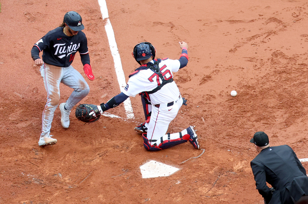 Minnesota Twins' Austin Martin, left, scores as Boston Red Sox catcher Carlos Narváez (75) misses a catch during the sixth inning of a baseball game, Sunday, May 24, 2026, in Boston. (AP Photo/Mark Stockwell)