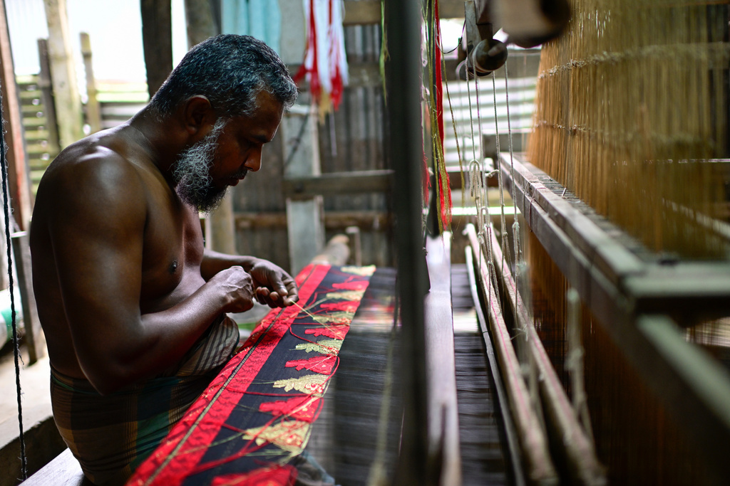 A weaver crafts a Tangail saree on a traditional hand-operated loom at a weaving workshop in Tangail District, Bangladesh, Nov. 5, 2025. (AP Photo/Mahmud Hossain Opu)