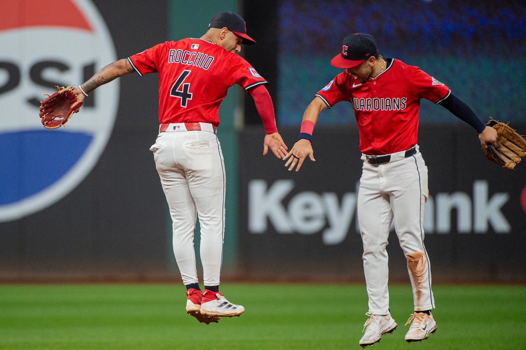 Cleveland Guardians' Brayan Rocchio (4) and Steven Kwan, right, celebrate at the end of a baseball game against the Detroit Tigers, Wednesday, Sept. 24, 2025, in Cleveland. (AP Photo/Phil Long)