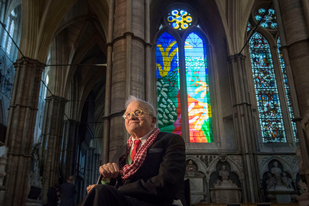 FILE - British artist David Hockney sits in front of The Queen's Window, a new stained glass window at Westminster Abbey, London, designed by David Hockney and revealed for the first time on Wednesday Sept. 26, 2018. (Victoria Jones/Pool via AP, File)