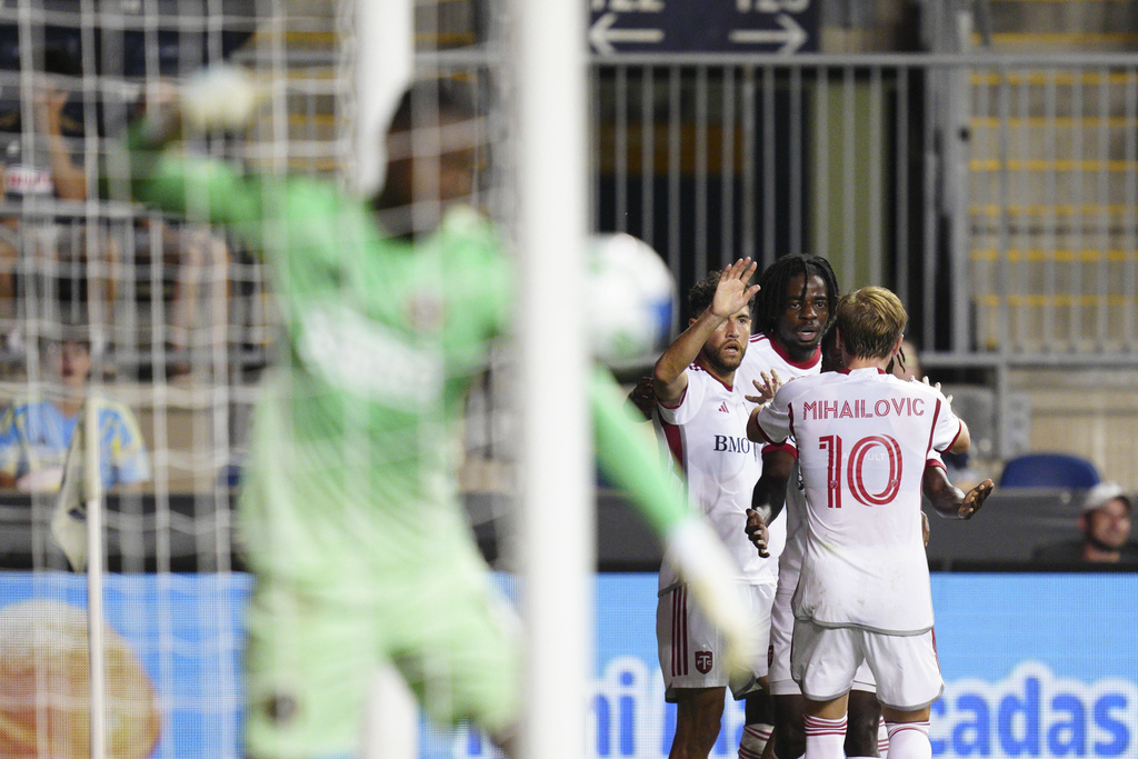 Toronto FC's Deandre Kerr, second from right, celebrates with teammates after scoring in stoppage time past Philadelphia Union goalkeeper Andre Blake, front left, during the second half of an MLS soccer match, Saturday, Aug. 9, 2025, in Chester, Pa. (AP Photo/Derik Hamilton)