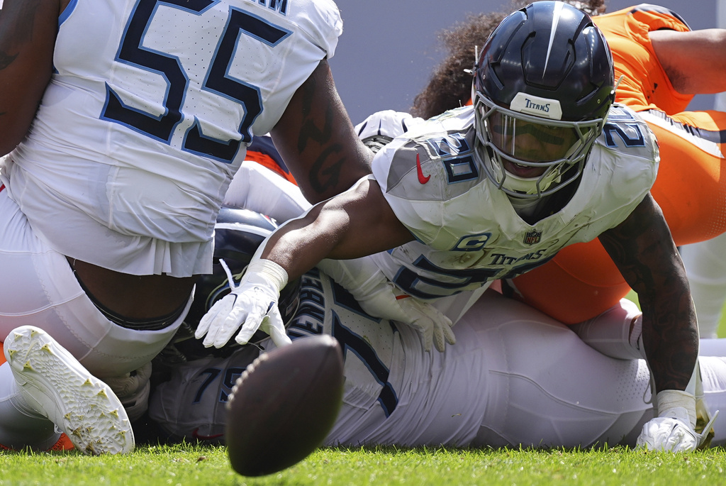 Tennessee Titans running back Tony Pollard (20) fumbles the ball during the first half of an NFL football game Sunday, Sept. 7, 2025, in Denver. (AP Photo/David Zalubowski)