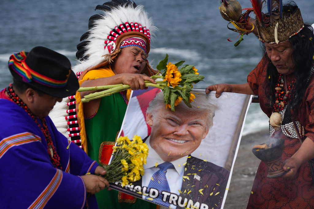 Shamans hold a photo of U.S. President Donald Trump during an annual ritual to predict political and social issues for the new year in Lima, Peru, Monday, Dec. 29, 2025. (AP Photo/Guadalupe Pardo)