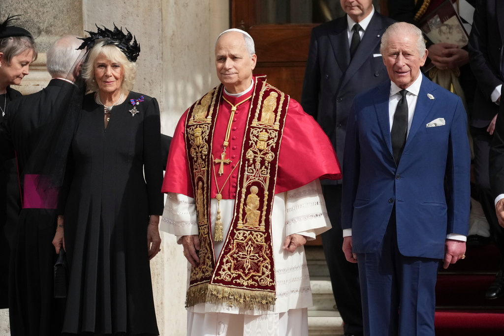 Pope Leo XIV, center, poses flanked by Britain's King Charles III and Queen Camilla in the St. Damasus Courtyard at the Vatican after a state visit and pray with him in the Sistine Chapel, Thursday, Oct. 23, 2025. (AP Photo/Andrew Medichini)