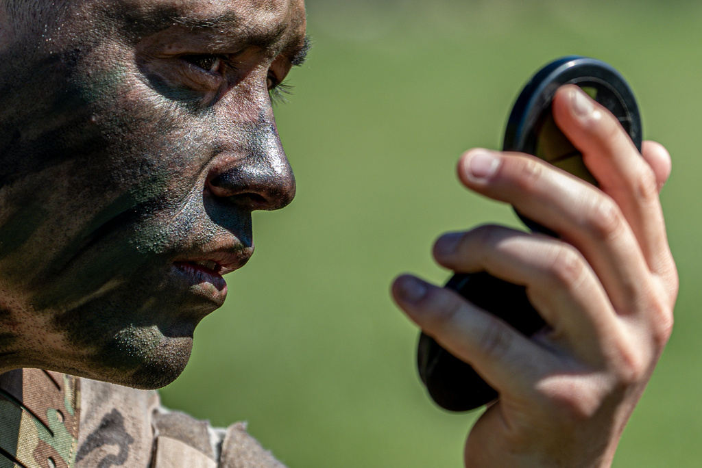 A cadet applies camouflage face paint before competing in the grenade assault course during the Sandhurst Military Skills Competition at the United States Military Academy in West Point, N.Y., Friday, May 1, 2026. (AP Photo/Julia Demaree Nikhinson)