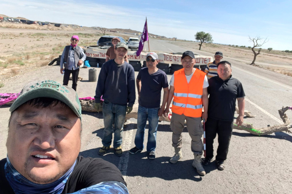 In this photo taken Wednesday, June 17, 2026 and released by Radical Reform Movement, protestors with the Radical Reform Movement pose for a selfie photo after blocking a road used by trucks transporting copper from the Oyu Tolgoi mine, developed by Rio Tinto, in White Rock of South Gobi region near the border with China in Mongolia. (Radical Reform Movement via AP)