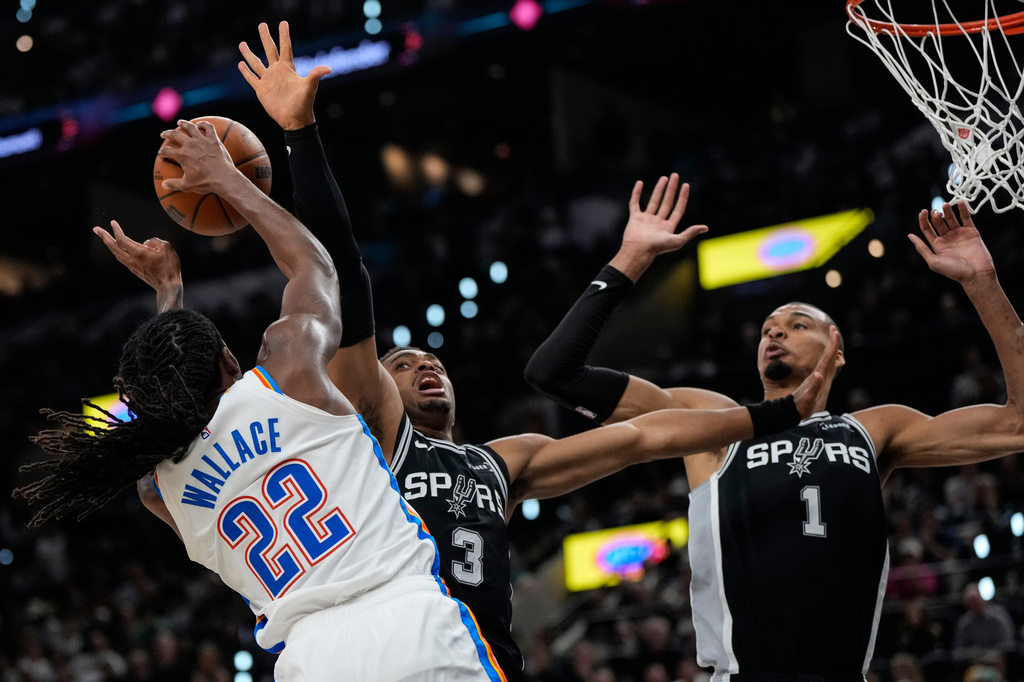 Oklahoma City Thunder guard Cason Wallace (22) shoots against San Antonio Spurs forward Keldon Johnson (3) in the second half of Game 6 in the Western Conference finals NBA basketball playoffs series, Thursday, May 28, 2026, in San Antonio. (AP Photo/David J. Phillip)