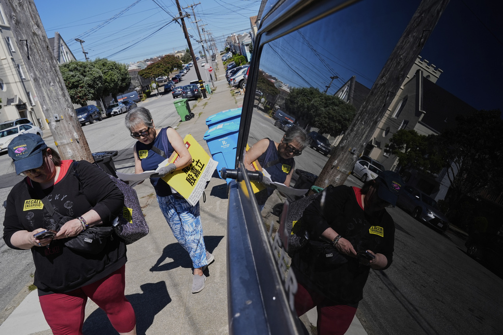 From left, Lori Milburn and So Kwong check their list of addresses to knock on in hopes to get Sunset District residents to recall Supervisor Joel Engardio, Monday, Sept. 15, 2025, in San Francisco. (AP Photo/Godofredo A. Vásquez)