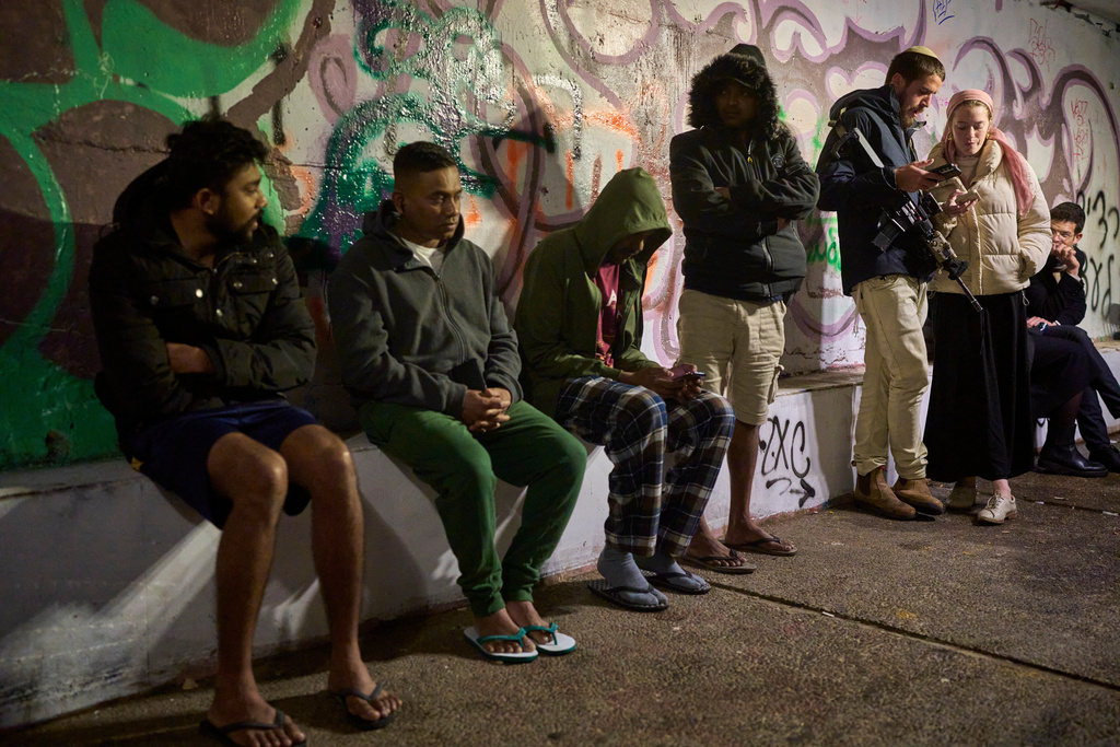 People take shelter in an Underground tunnel as air raid sirens signal a warning of incoming Iranian missiles in Jerusalem, Thursday, March 19, 2026. (AP Photo/Ohad Zwigenberg)