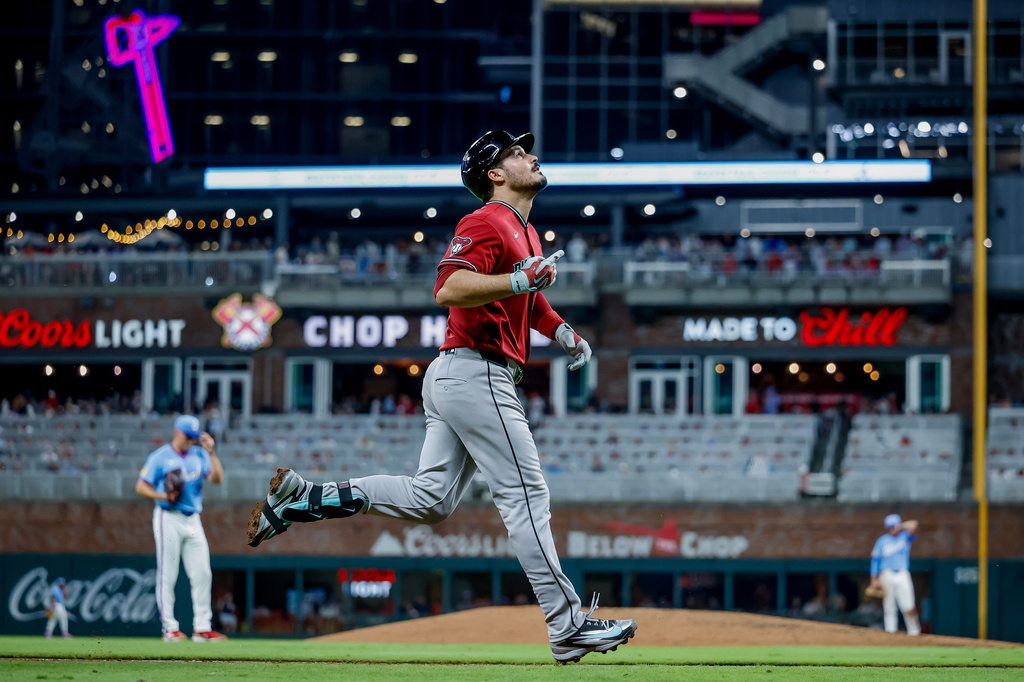 Arizona Diamondbacks' Nolan Arenado, right, reacts while rounding the bases after hitting a solo home run off Atlanta Braves pitcher Brent Suter, left, during the seventh inning of a baseball game, Saturday, Aug. 15, 2026, in Atlanta. (AP Photo/Erik S. Lesser)