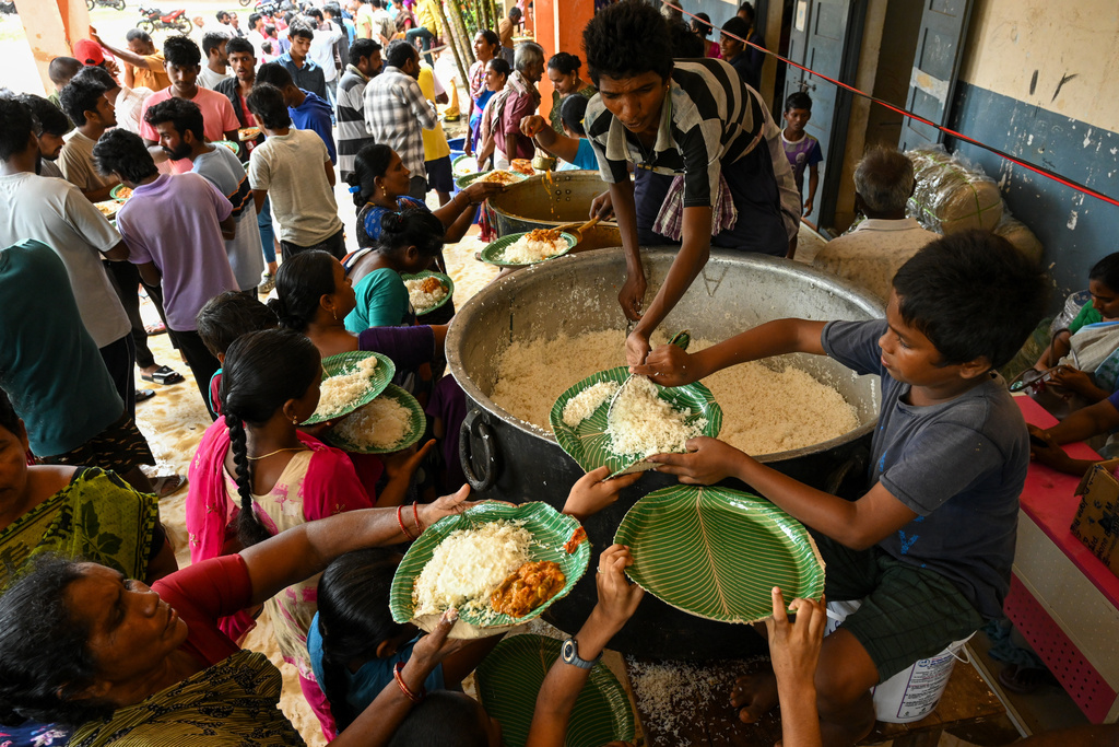 Evacuated Indian villagers of Uppada collect food to eat in a temporary relief centre as Cyclone Montha, in Kakinada district of Andhra Pradesh, India, Tuesday, Oct. 28, 2025. (AP Photo)