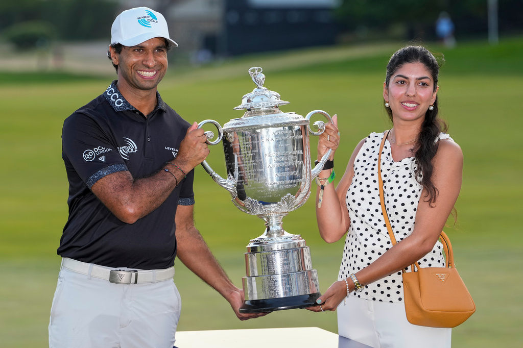 Aaron Rai, of England, and wife Gaurika Bishnoi hold the Wanamaker Trophy after winning the PGA Championship golf tournament at Aronimink Golf Club, Sunday, May 17, 2026, in Newtown Square, PA. (AP Photo/Frank Franklin II)