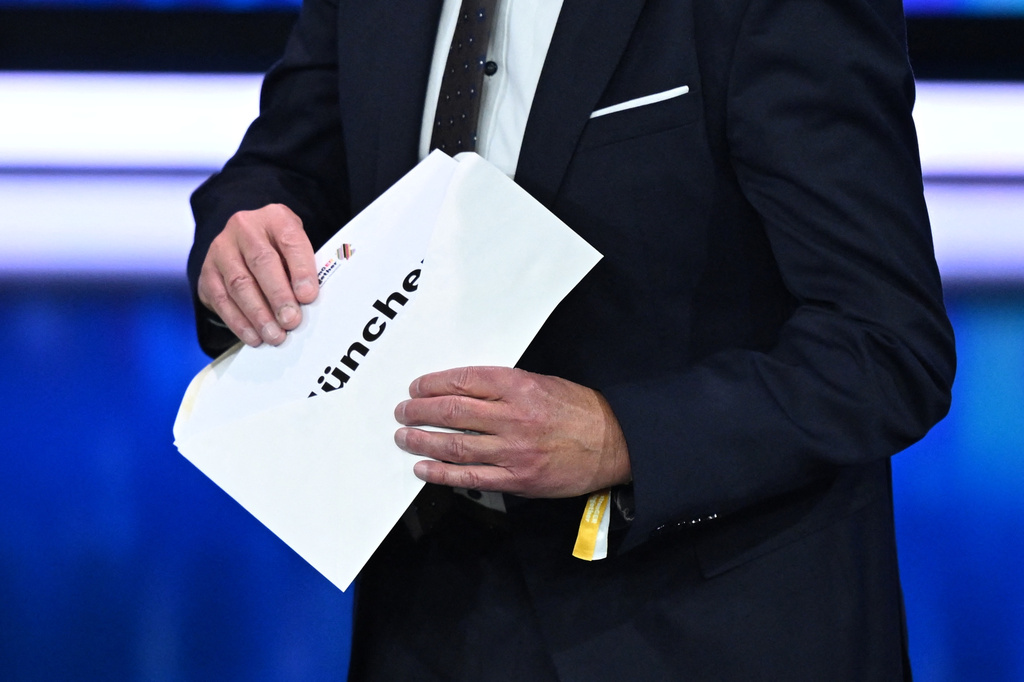 Thomas Weikert, President of the German Olympic Sports Confederation (DOSB), opens the envelope on stage at the extraordinary DOSB General Assembly to select Germany's Olympic bid for 2036, 2040, or 2044, in Baden-Baden, Germany, Saturday Sept. 26, 2026. Munich is Germany's candidate city. (Marijan Murat/dpa via AP)