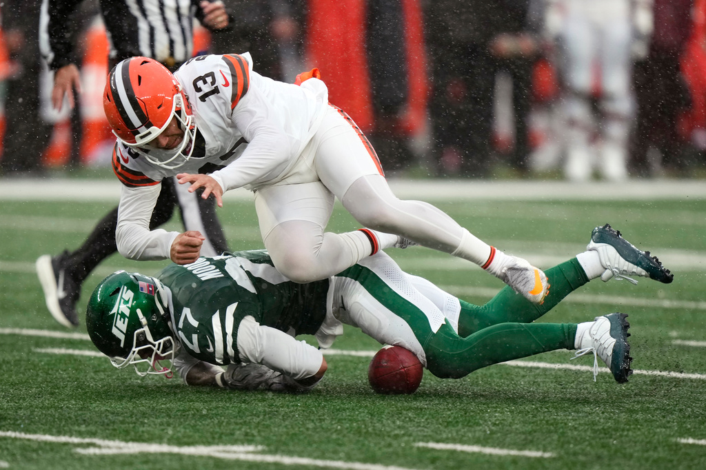 Cleveland Browns punter Corey Bojorquez (13) fights for a fumbled snap with New York Jets safety Malachi Moore (27) during the second half of an NFL football game, Sunday, Oct. 11, 2026, in East Rutherford, N.J. (AP Photo/Seth Wenig)