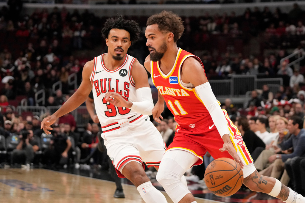 Atlanta Hawks guard Trae Young, right, drives the ball as Chicago Bulls guard Tre Jones, left, defends during the first half of an NBA basketball game Monday, Oct. 27, 2025, in Chicago. (AP Photo/David Banks)