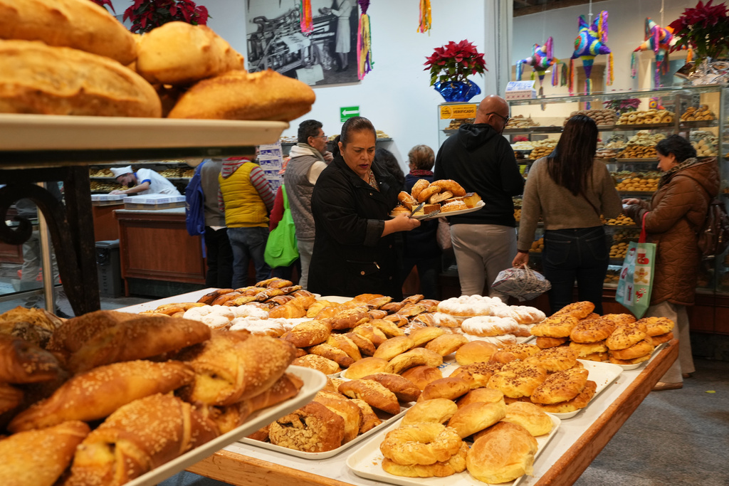 People buy pastries at a bakery in Mexico City, Thursday, Dec. 18, 2025. (AP Photo/Marco Ugarte)
